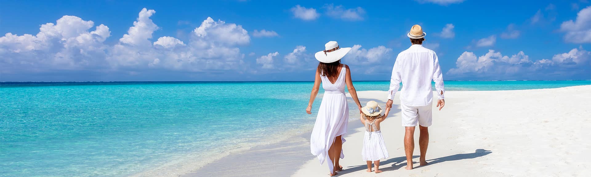 Family holding hands walking along a beautiful beach